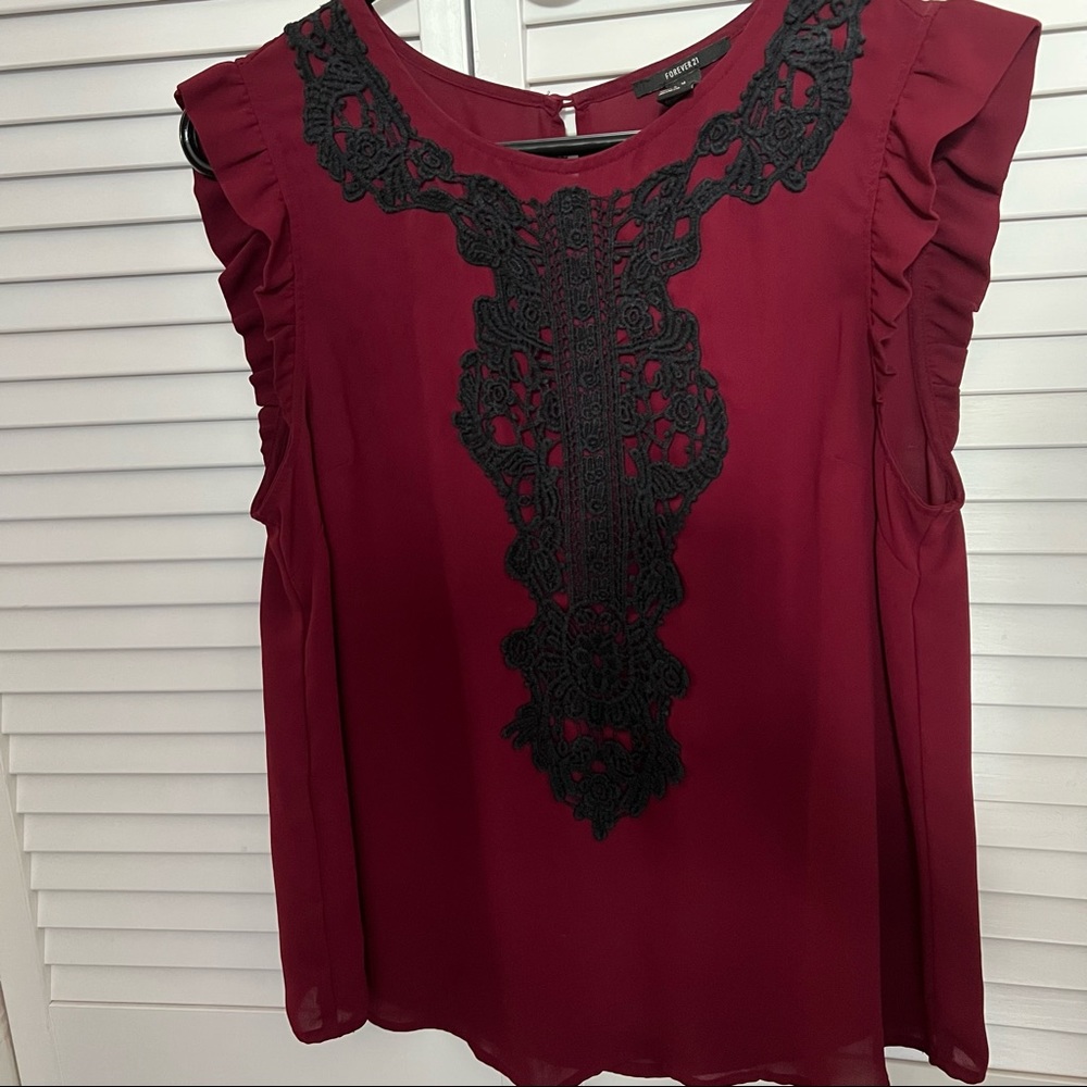 Medium burgundy ruffled sleeve sheer tank top with black lace design on front